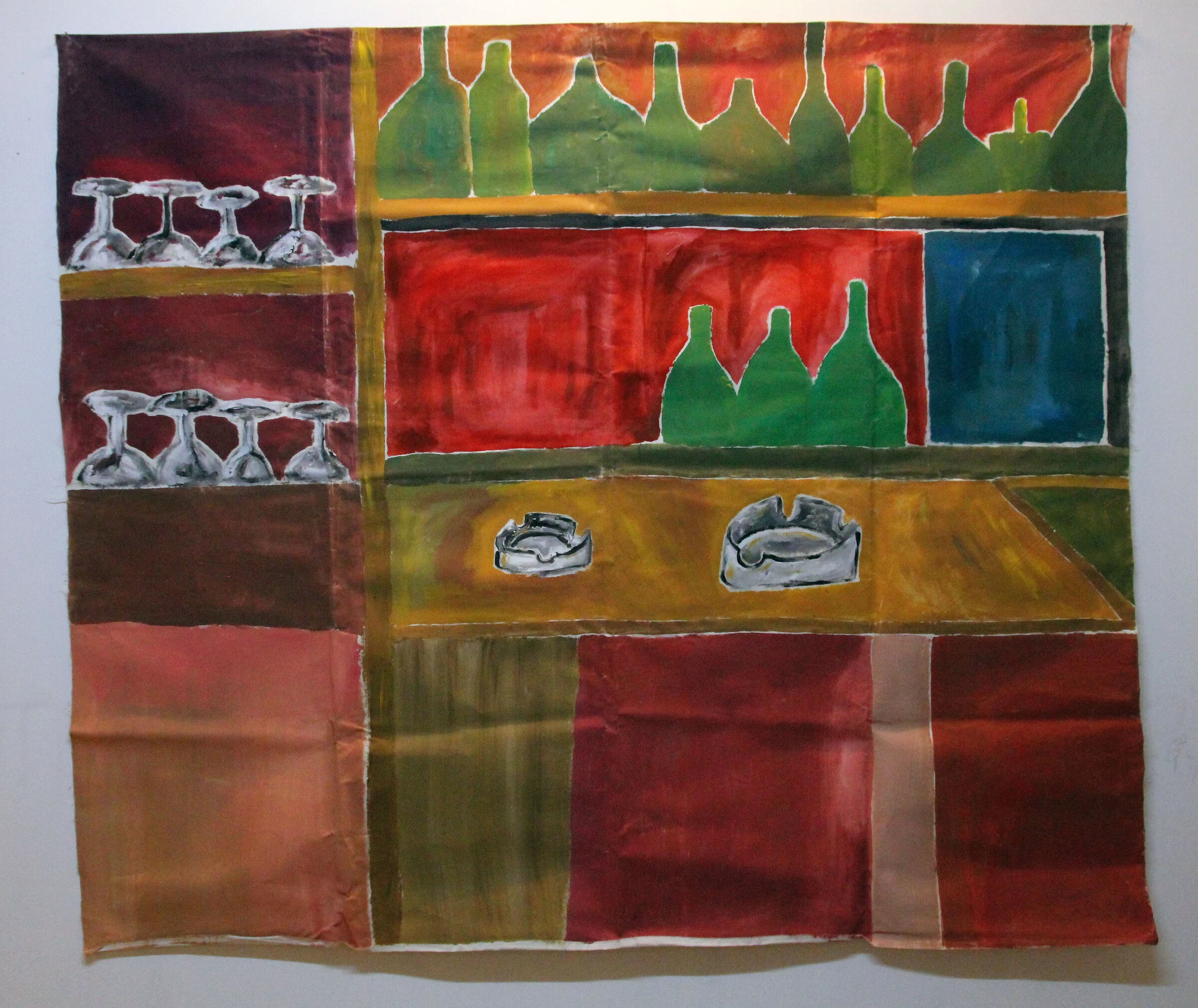 A painted bar backdrop with shelves of green bottles and wine glasses above two grey ashtrays on a brown counter.