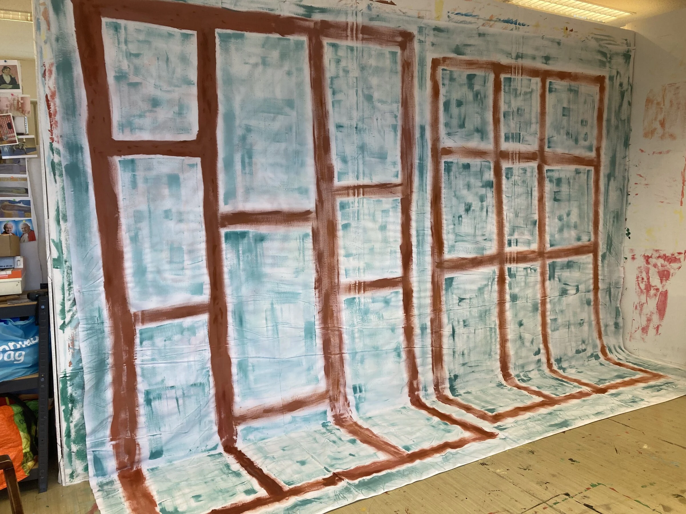 A painted window backdrop with reddish brown frames and pale blue panes.