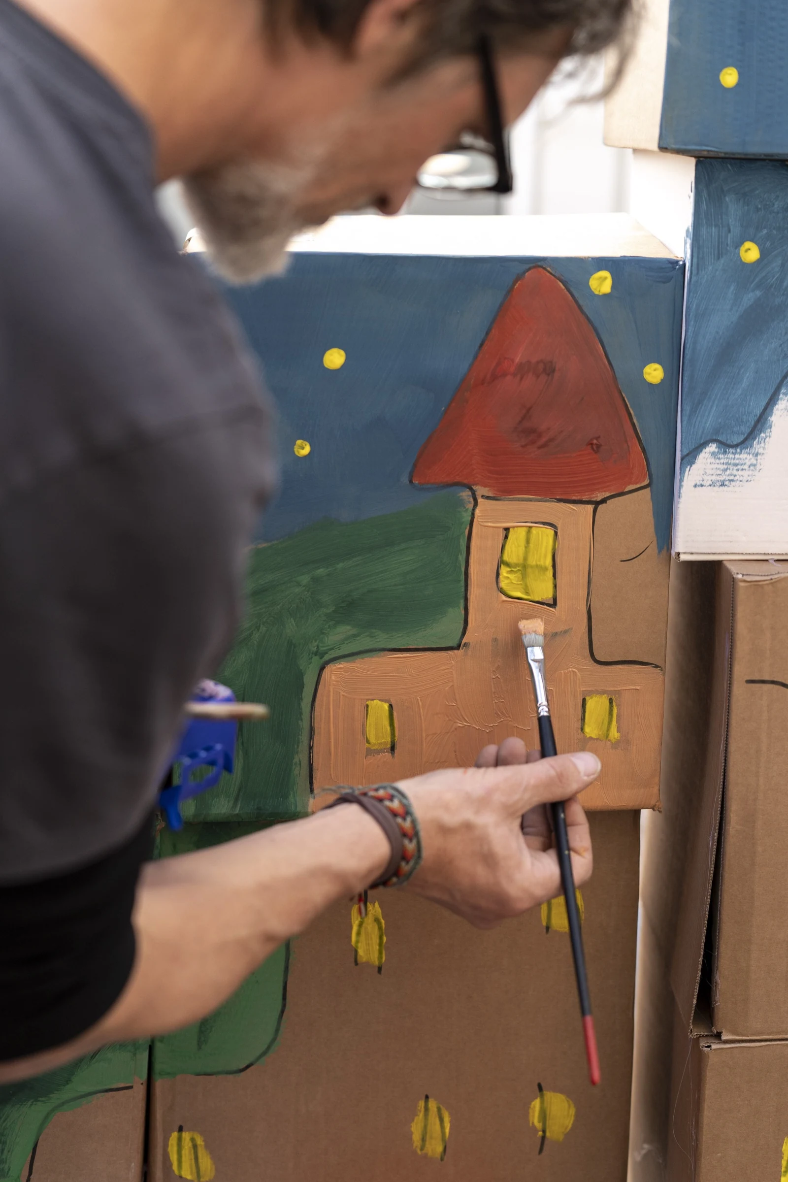 A participant painting the windows of a cardboard castle.