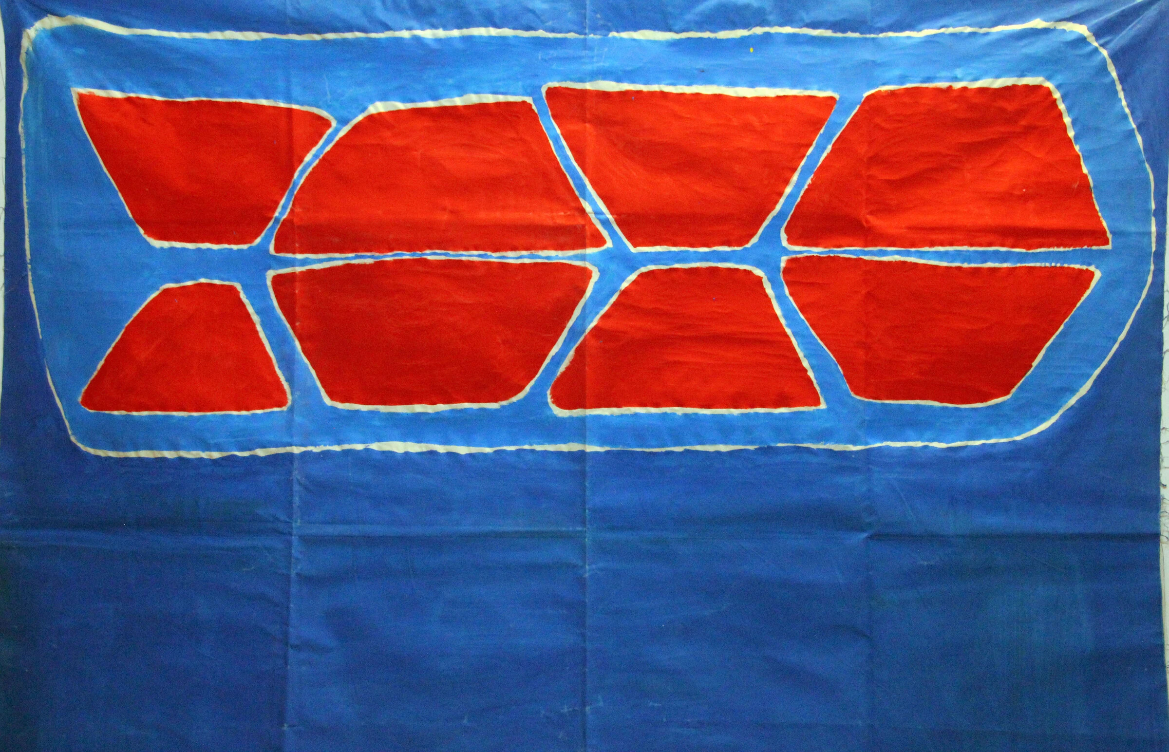A close-up of red geometric shapes outlined in white on the blue backdrop.