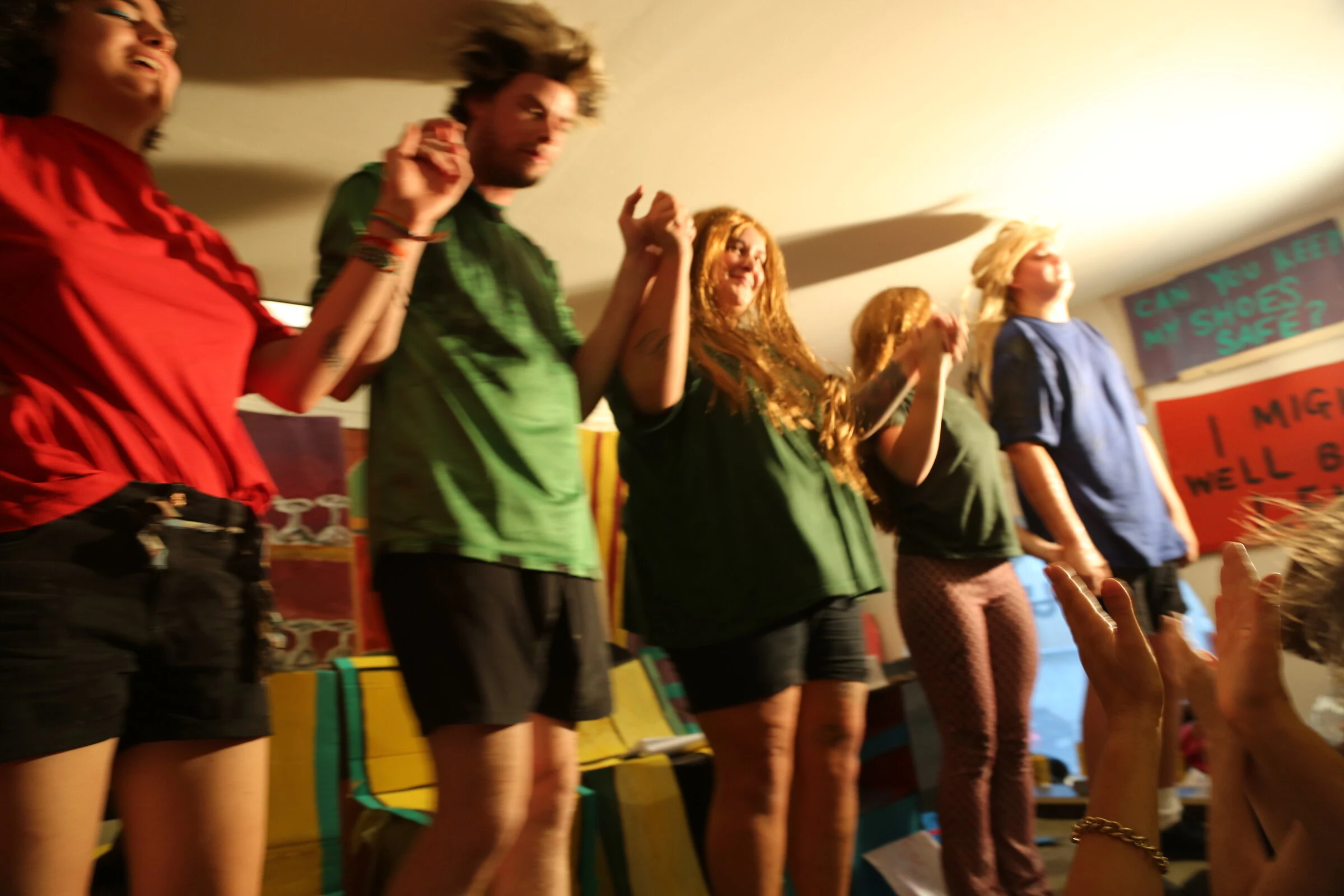 Five performers taking a bow in front of the colourful handmade set.