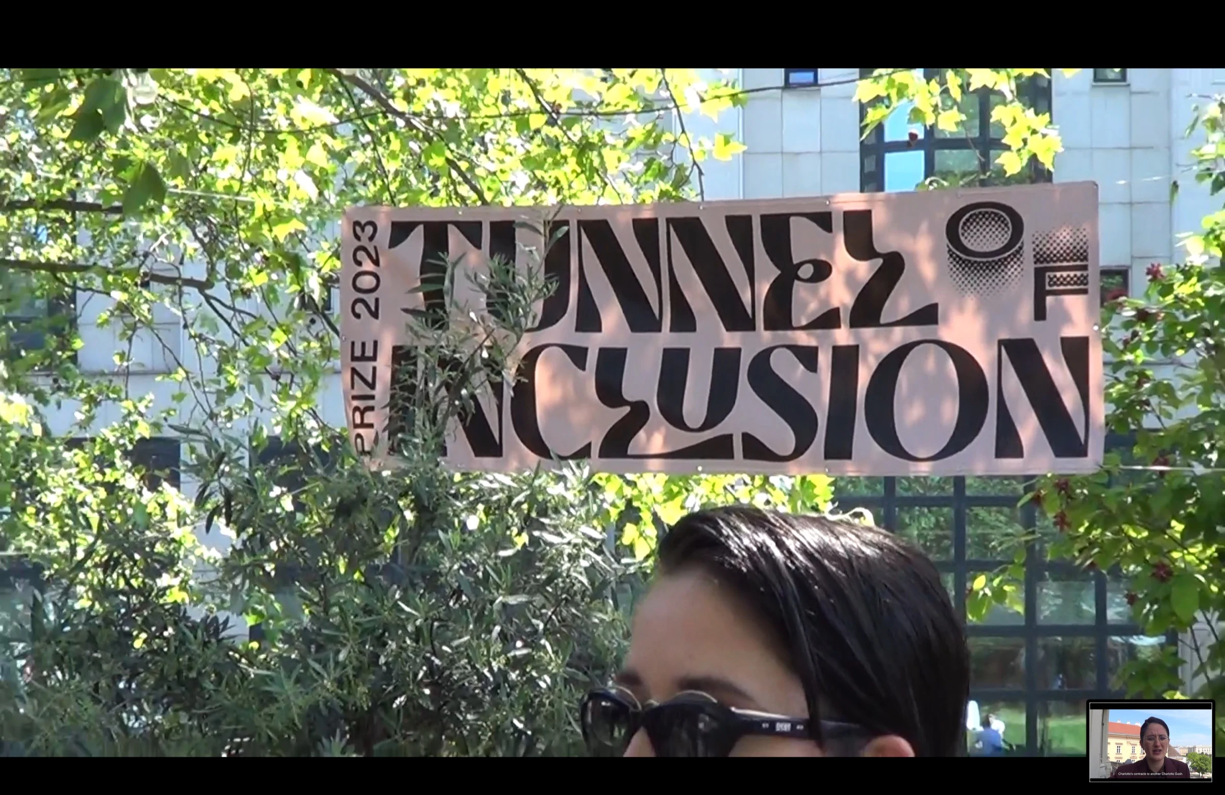A Tunnel of Inclusion Prize 2023 banner among trees, with a character wearing sunglasses in the foreground.