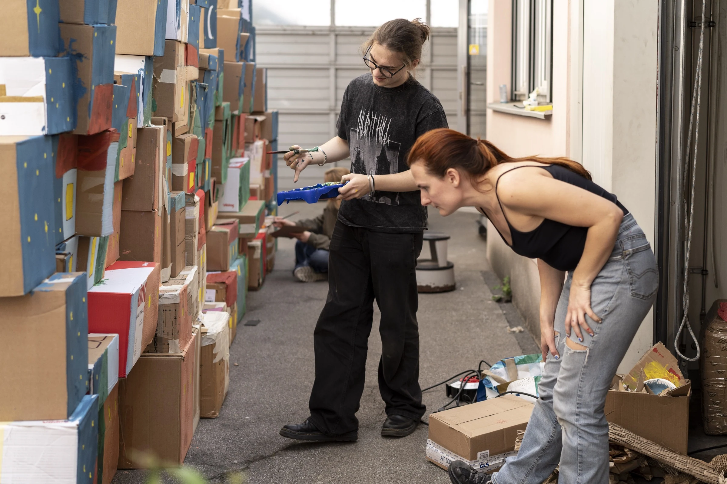 Charlotte Gash and a participant looking at the painted cardboard scenery.