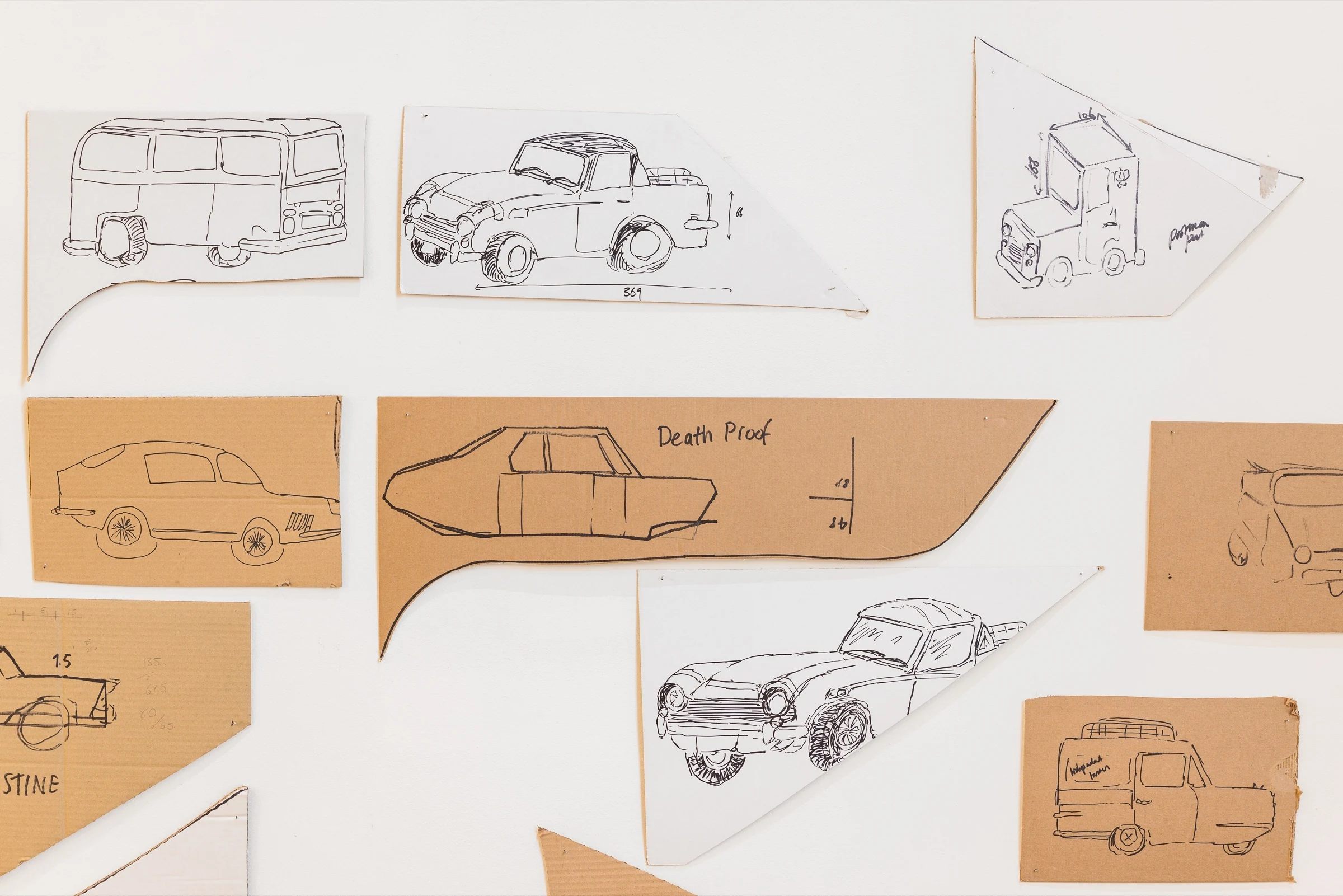 Car sketches and measurements drawn on scraps of cardboard and white paper.