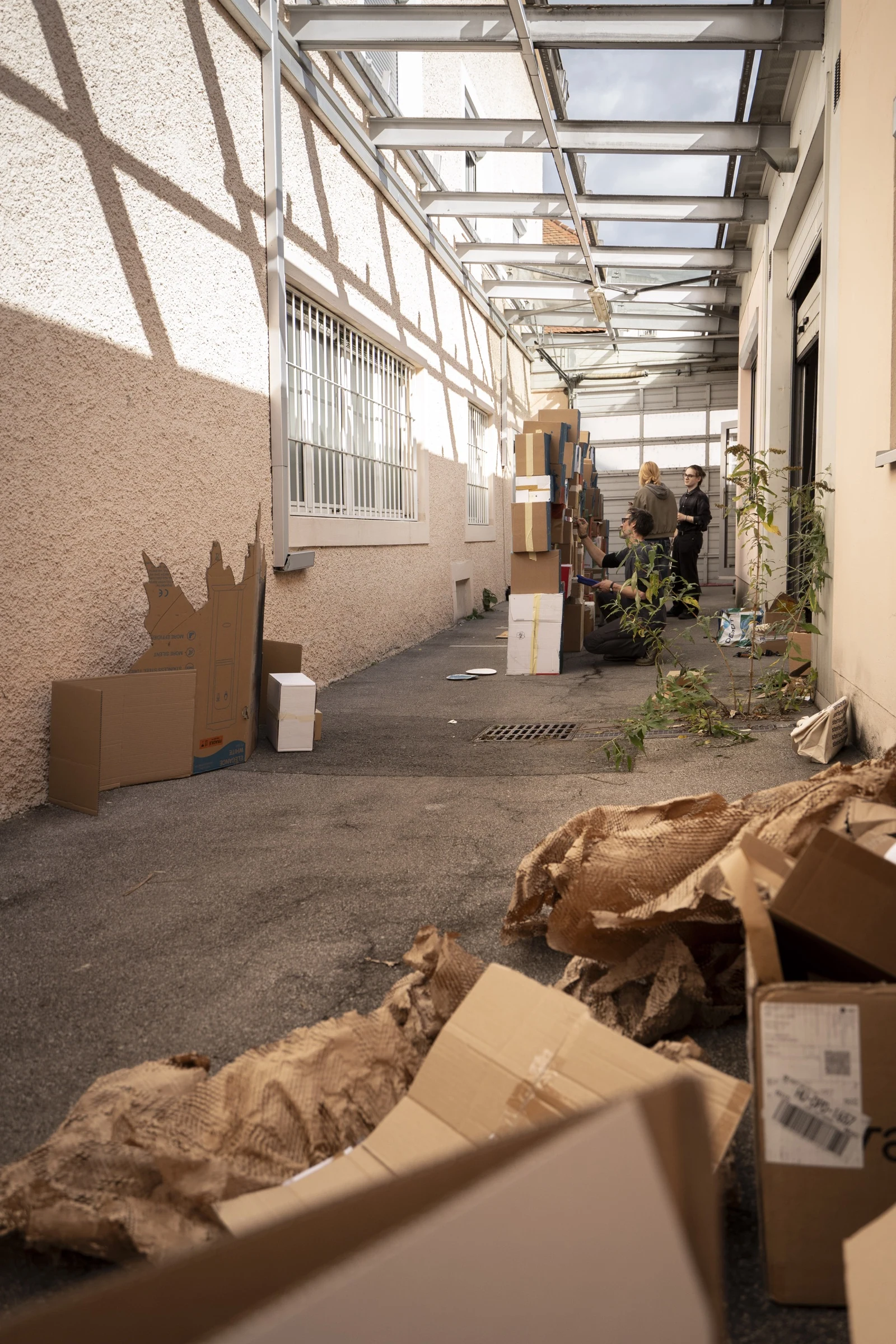 Workshop participants assembling cardboard scenery in a courtyard.