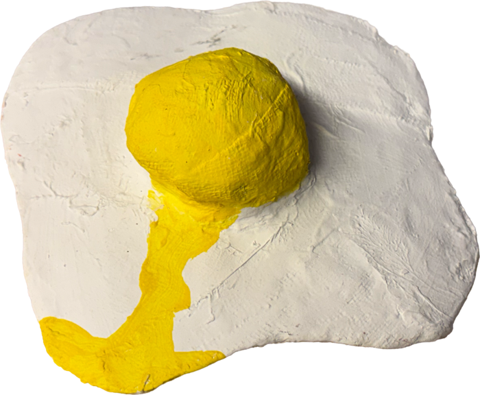 A handmade fried egg sculpture with a bright yellow yolk.