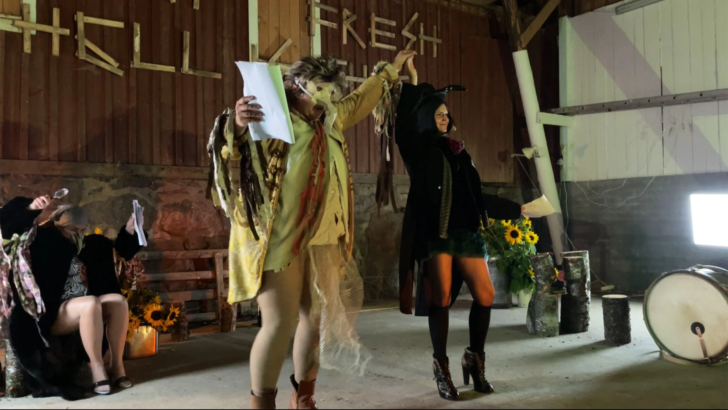 Two performers raising their joined hands while holding scripts.