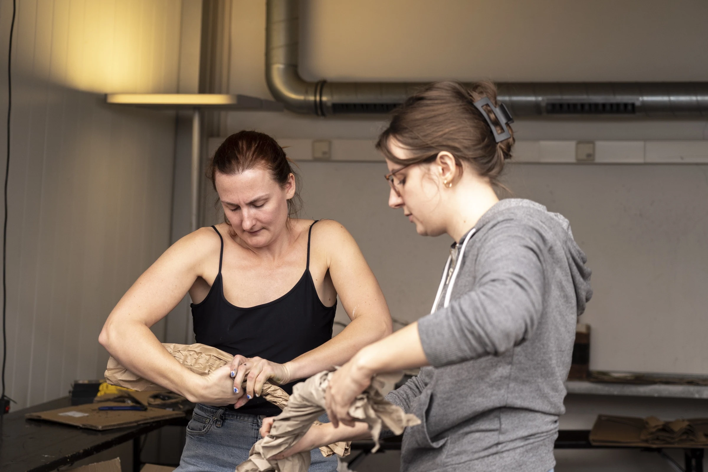 Charlotte Gash and a participant twisting paper into a prop.