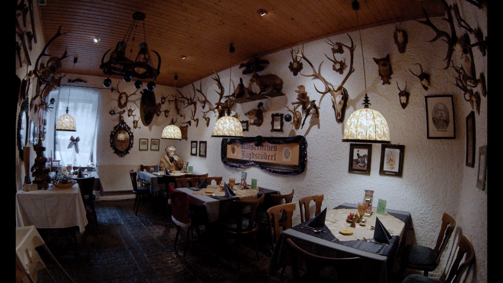A restaurant interior with mounted antlers and hanging lamps.