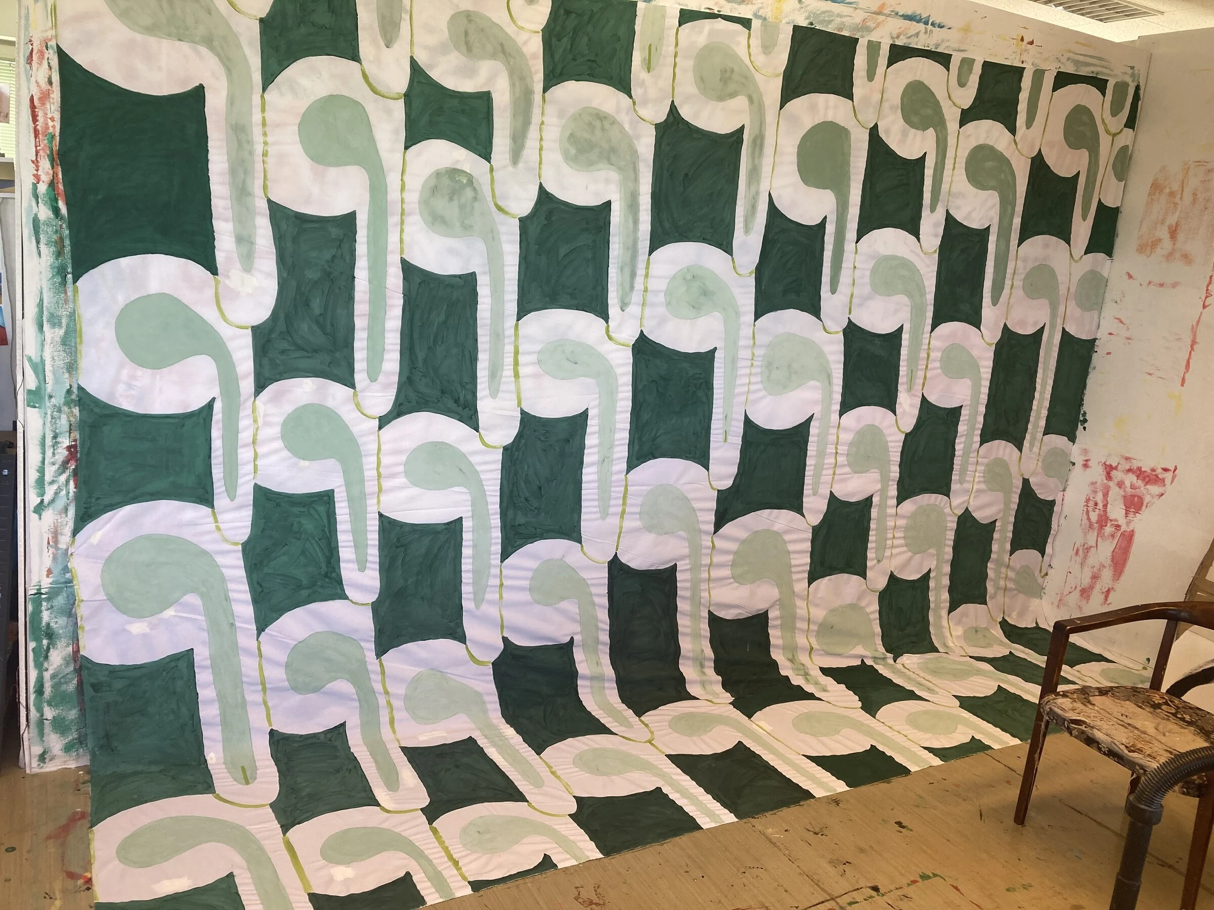 A green and white patterned canvas backdrop spread across the studio wall and floor.