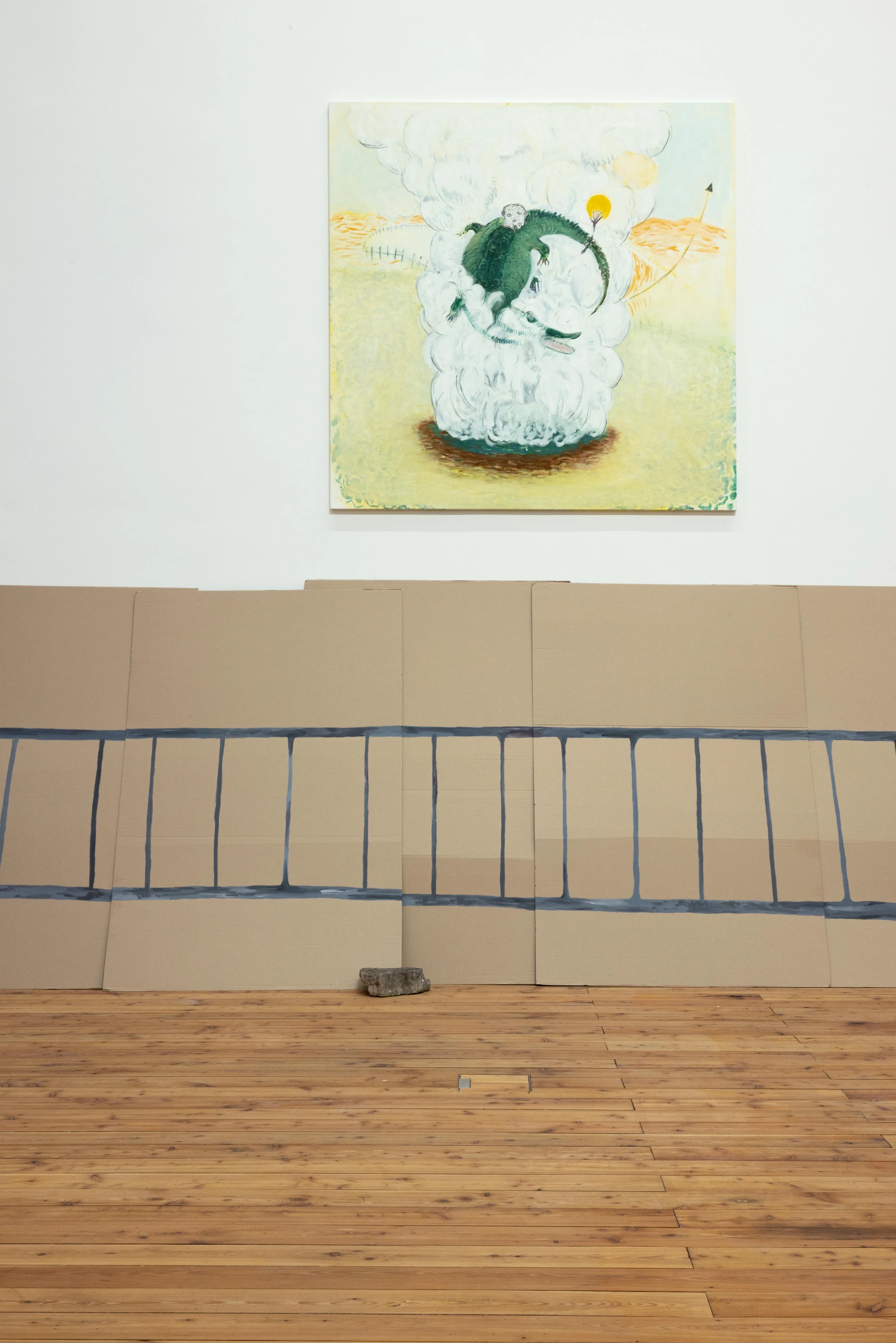 Cardboard fence panels beneath a painting on a white gallery wall.