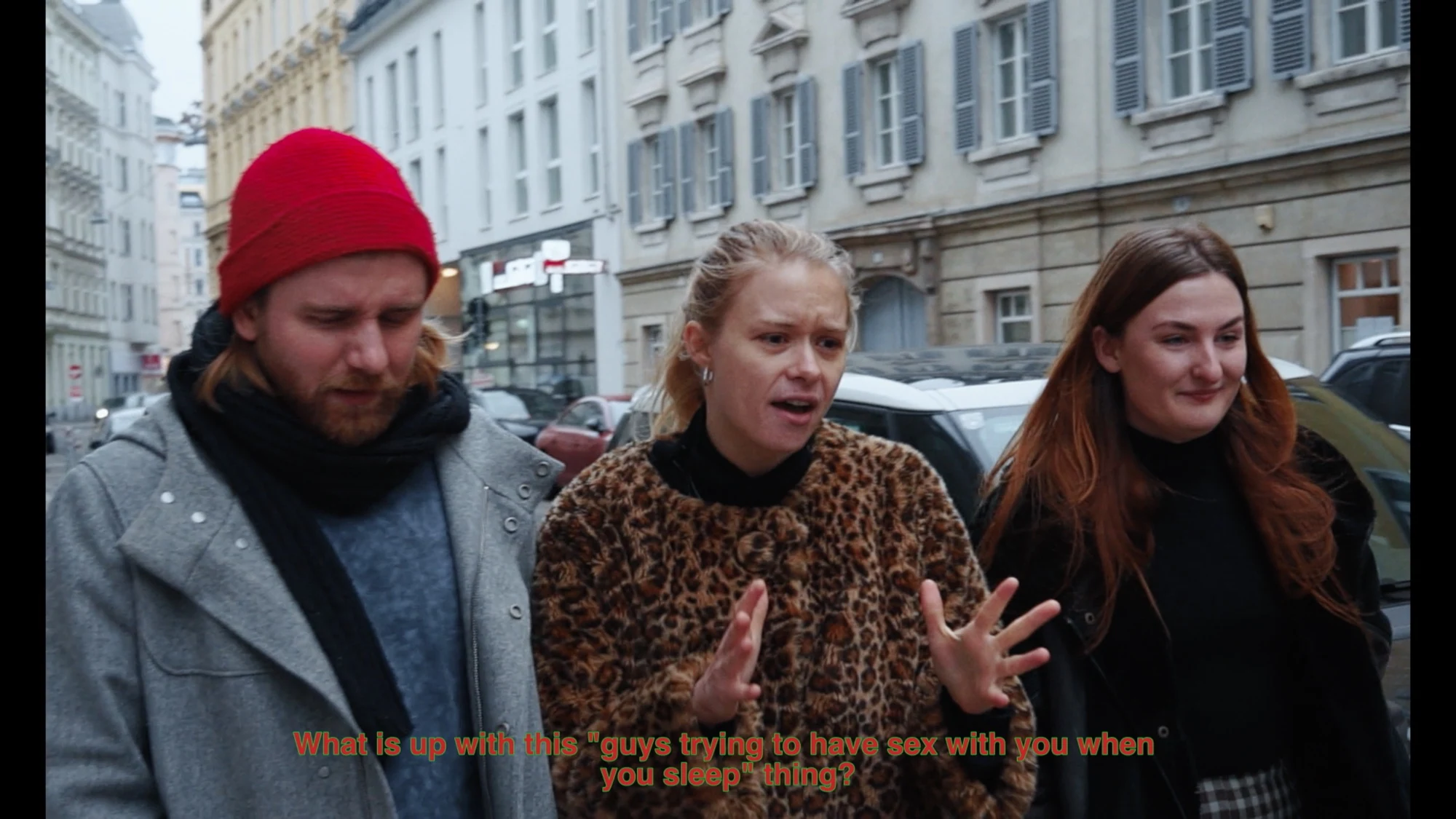 Three people talking together on a city street.