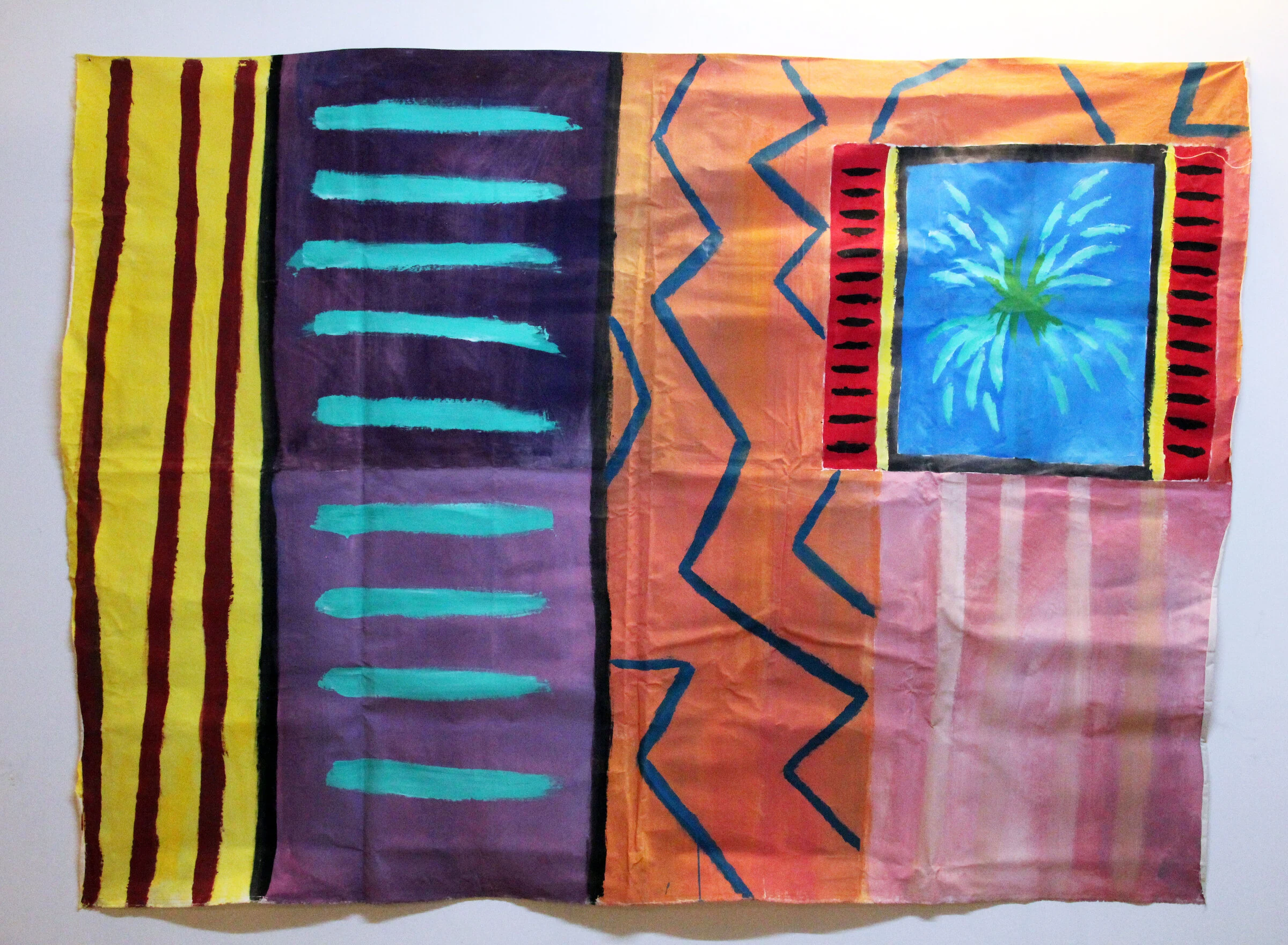 A colourful interior backdrop with teal stripes on purple, blue zigzags on orange and a framed blue window with a green plant.