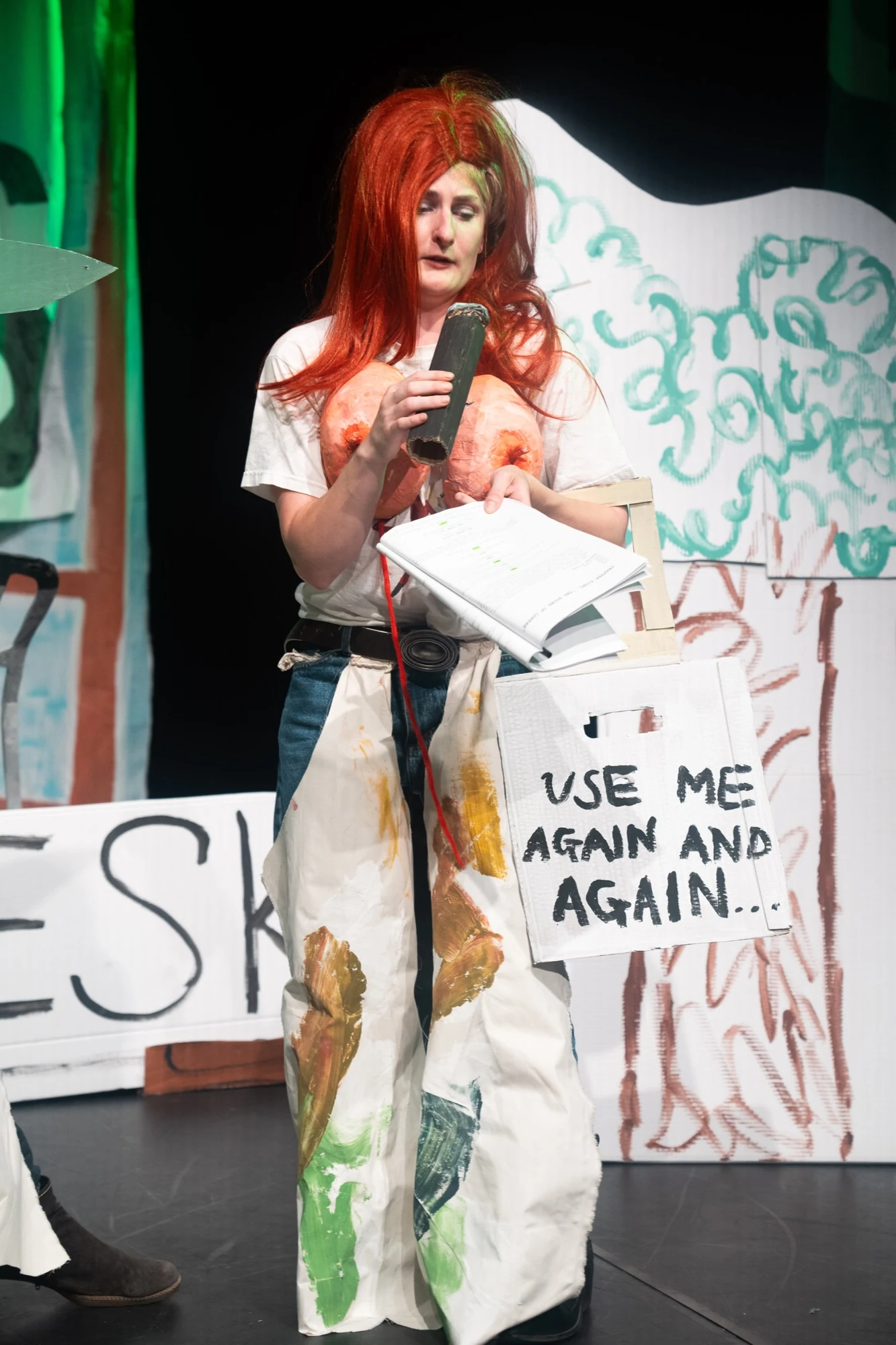 Charlotte performing with a cardboard microphone, script and handmade costume props.