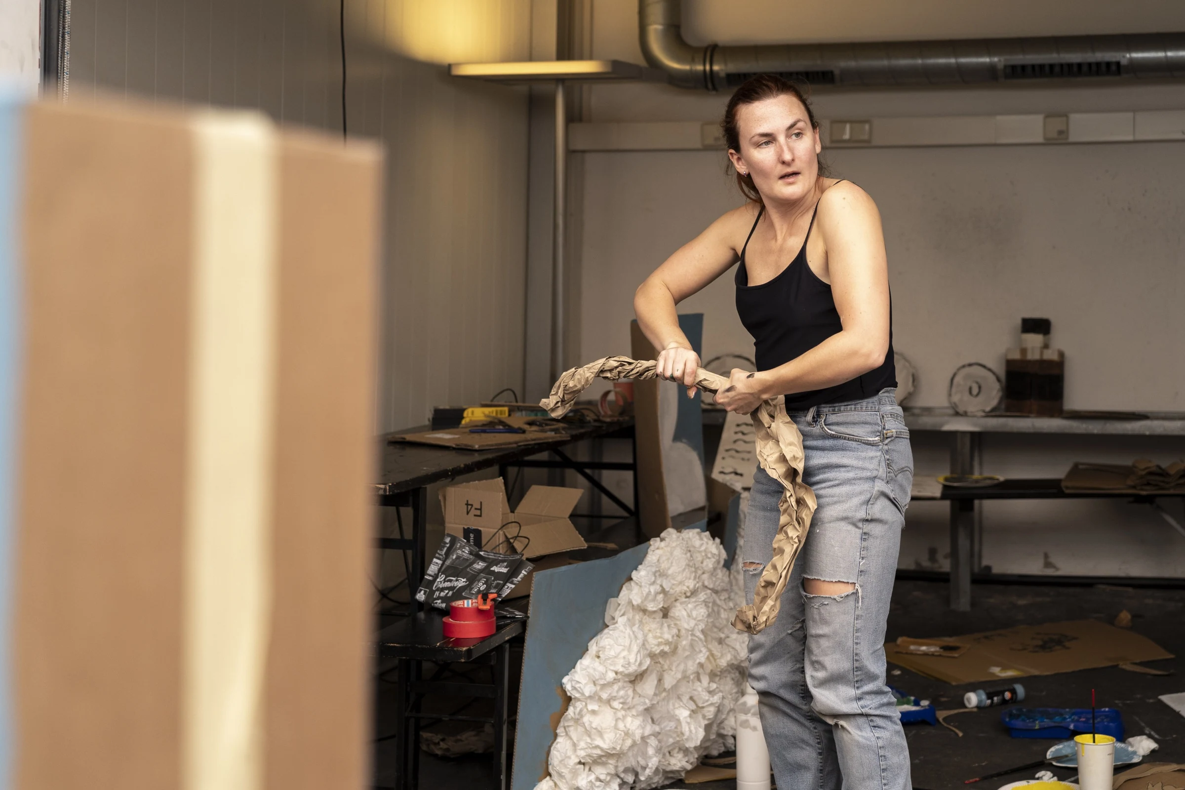 Charlotte Gash holding a twisted paper prop in the workshop.
