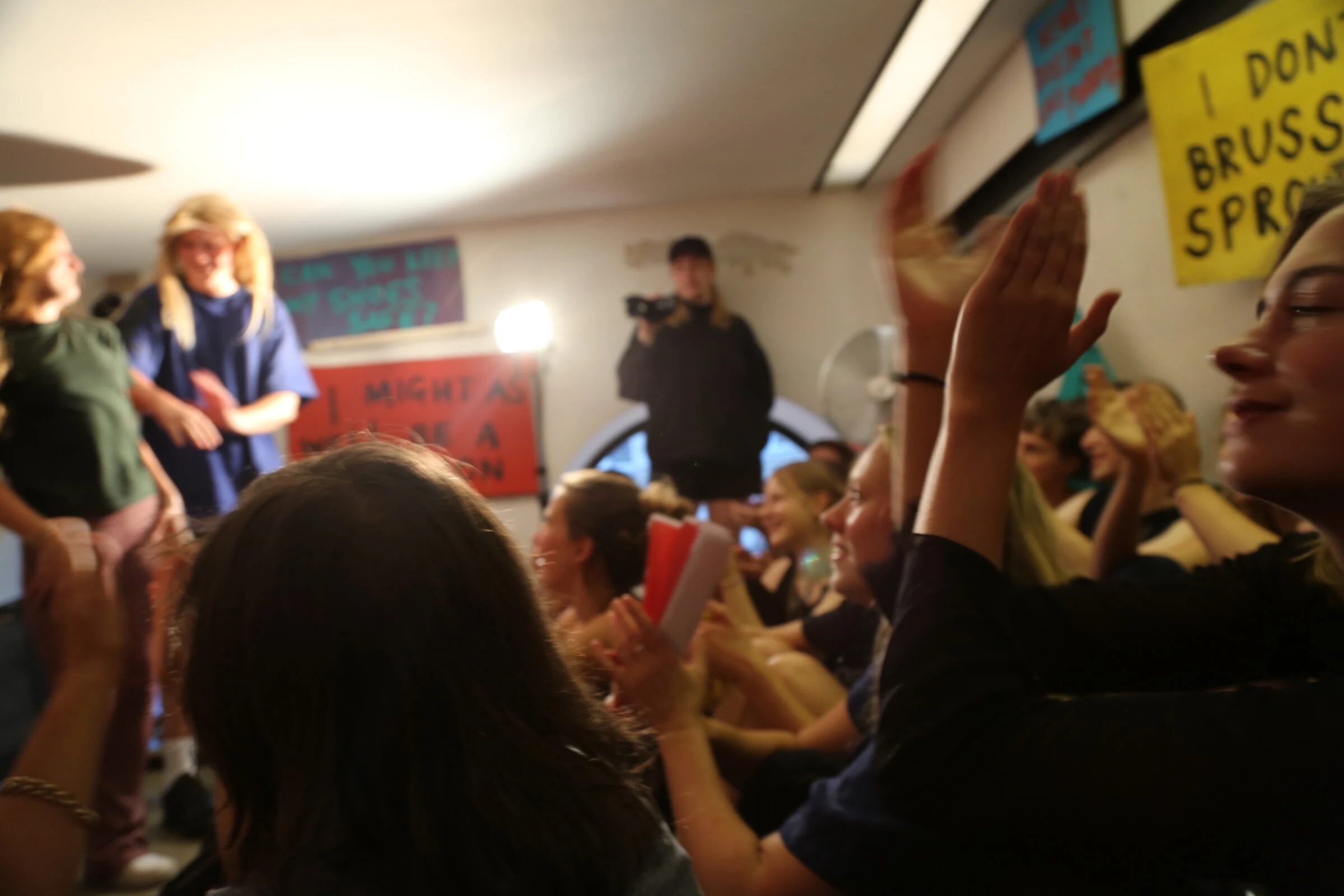 Audience members applauding the performers in the crowded studio.