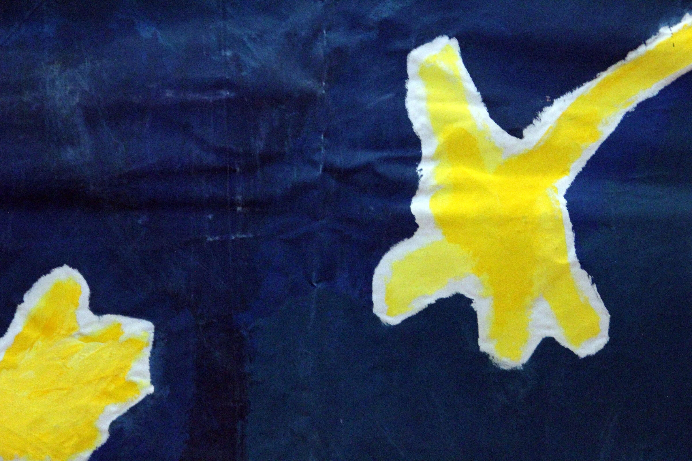 A close-up of yellow flowers painted on a dark blue canvas backdrop.