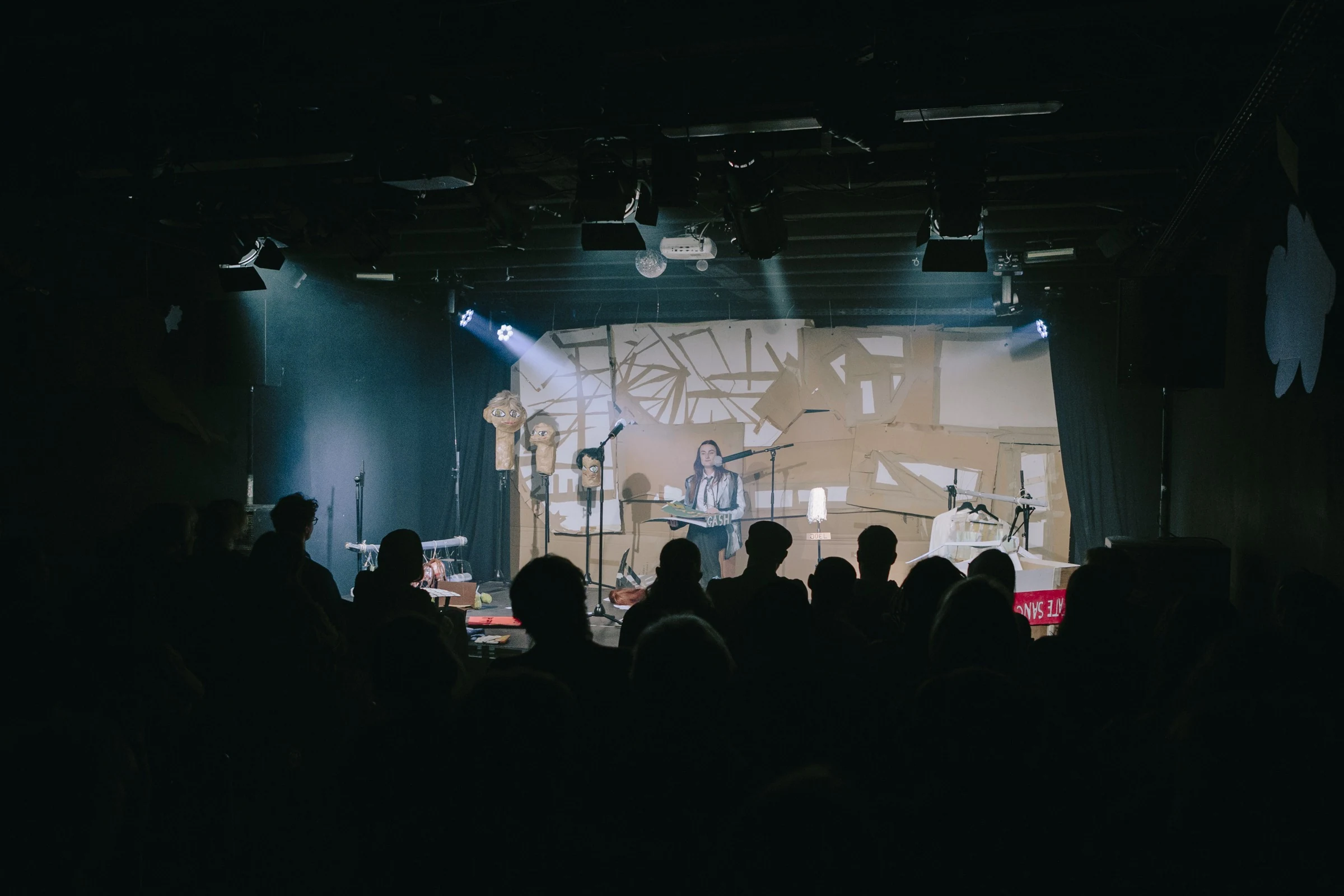 A wide view of the Gash Club stage and audience under blue lighting.