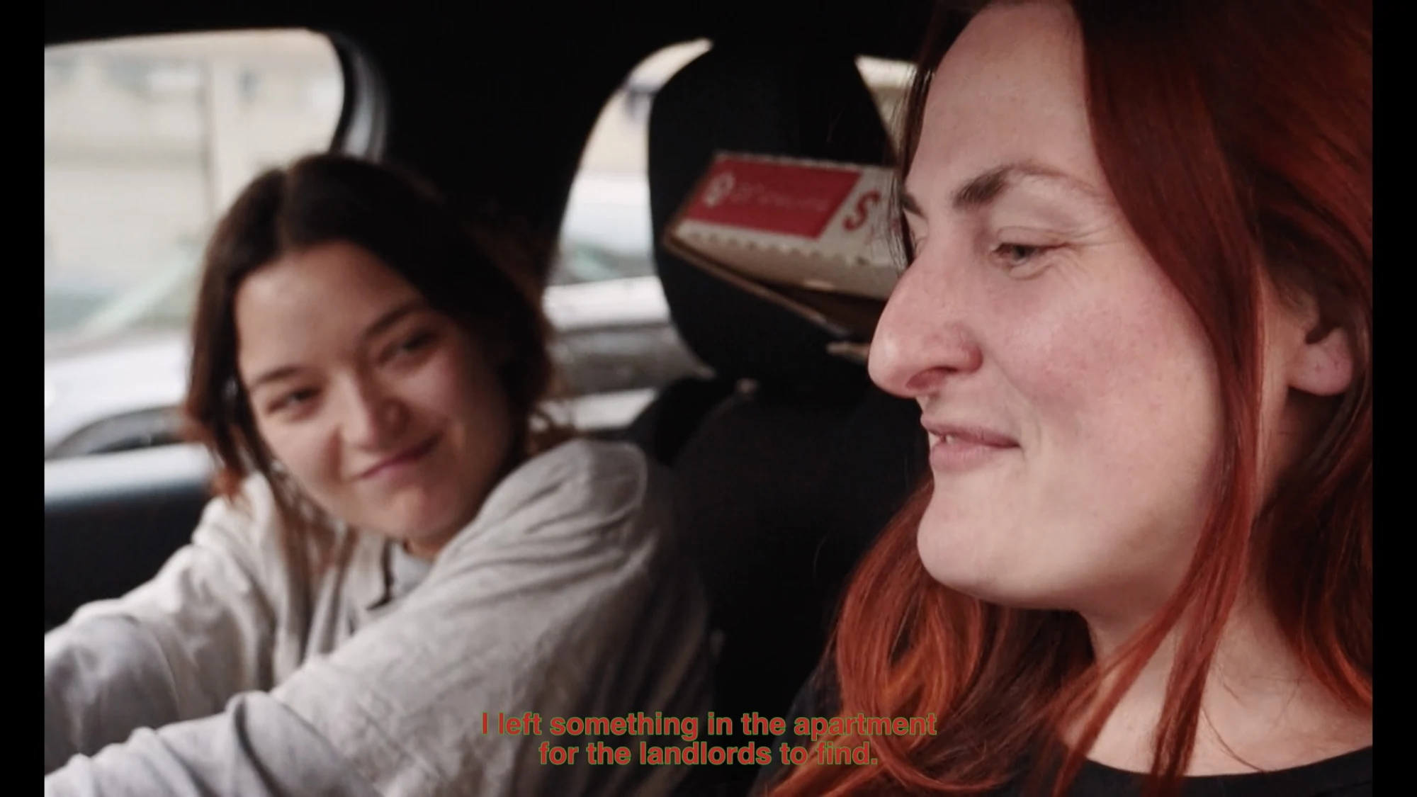 Two women talking inside a car.