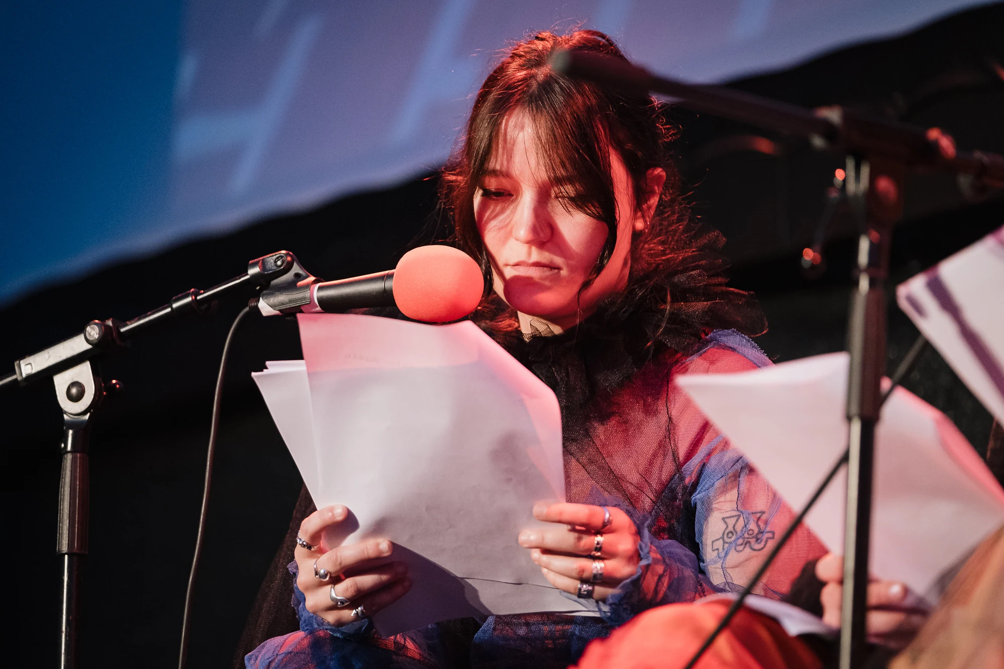 A performer in a purple costume reading a script into a microphone.
