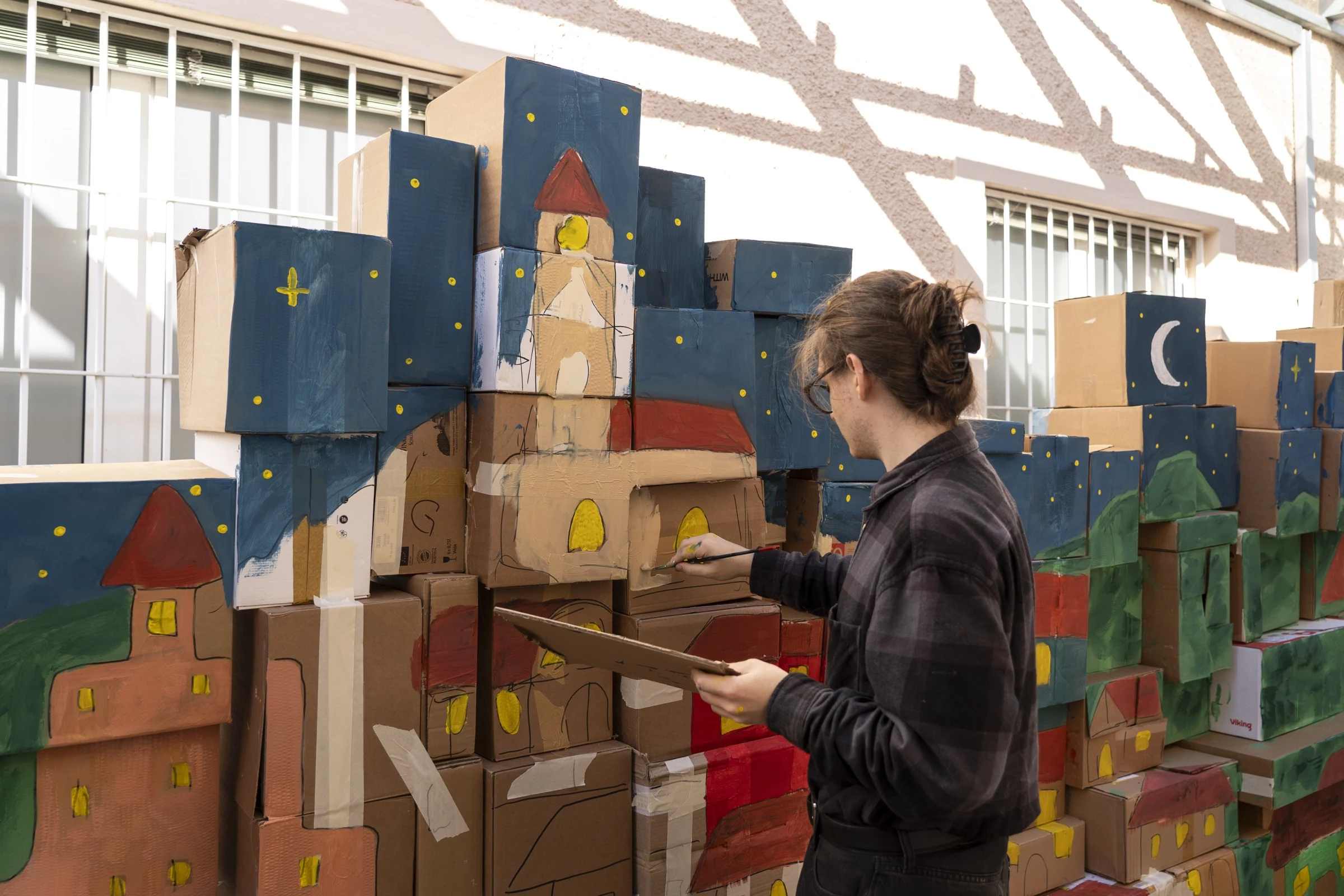 A participant painting the castle while holding a cardboard palette.