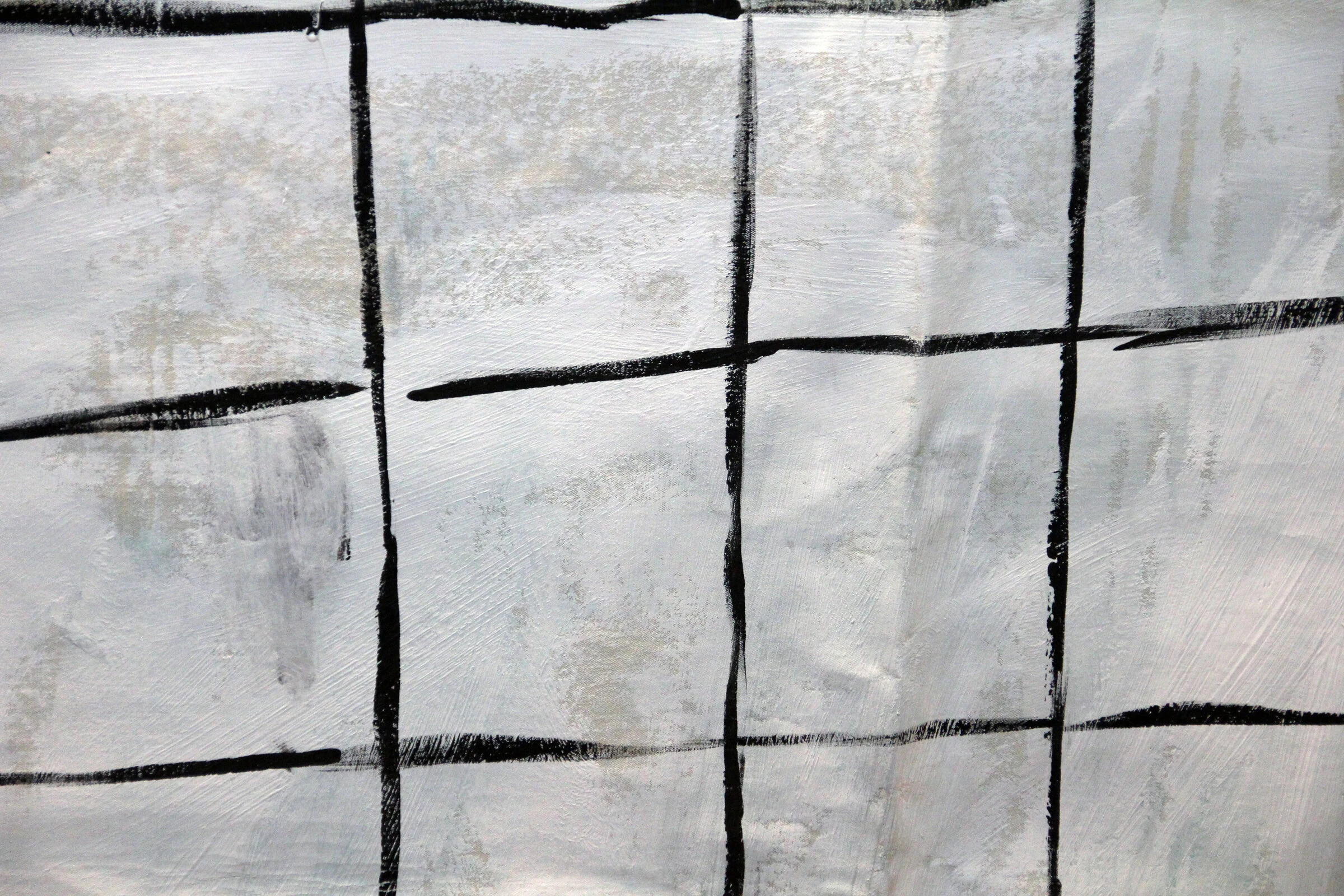 A close-up of black grid lines painted on white canvas.