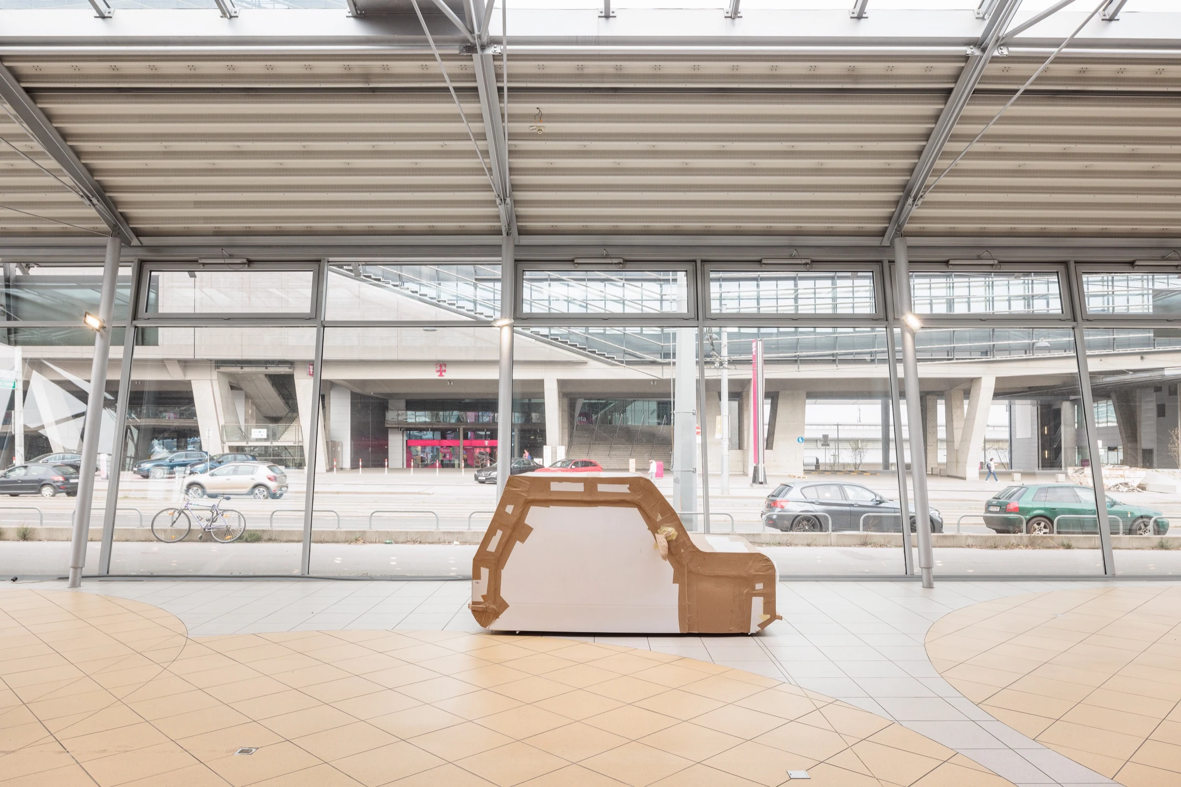 A full-size cardboard car in profile beside the showroom windows.